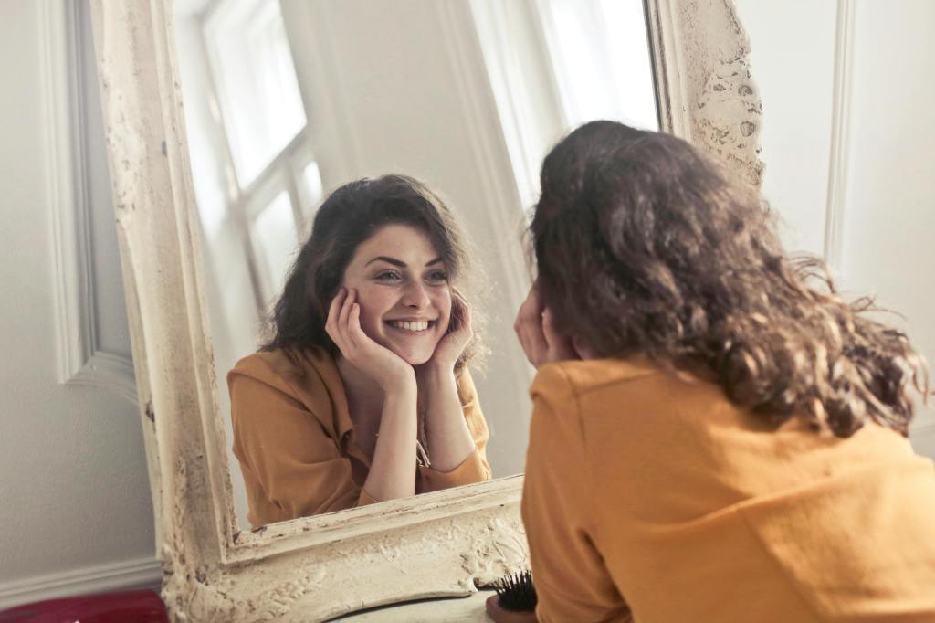 An image of a happy woman in a mirror. 